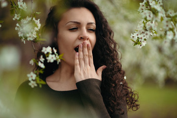 Portrait of yawning girl holding the hand posing in the nature