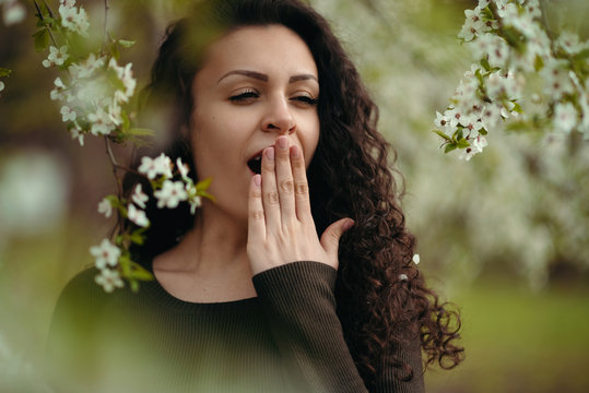 Portrait of yawning girl holding the hand posing in the nature - Powered by Adobe