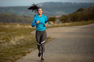Full length of young sportswoman road running in the morning.