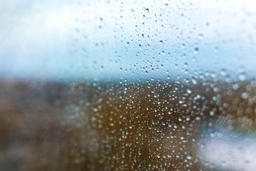 Naklejka na ściany i meble raindrops on the glass against the backdrop of the autumn city