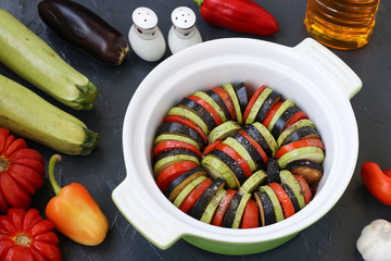 Vegetables for cooking process ratatouilles: zucchini, eggplant and tomatoes are in ceramic form on...