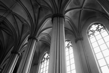 View of gothic medieval cathedral interior with columns and large windows. The Church of Sts. Olha and Elizabeth. Made in black and white colors