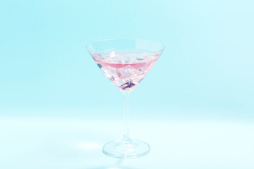 Cocktail in glass on blue background. Minimalism concept