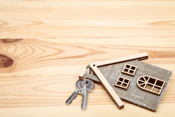 Silver keys with house symbol on brown wooden table