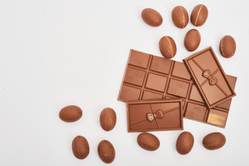 Delicious chocolate Easter bunny and eggs on white background top view copy space. Easter Greeting Card Template. Happy easter concept. Chocolate on white background. Chocolate Bars and Easter Sweets