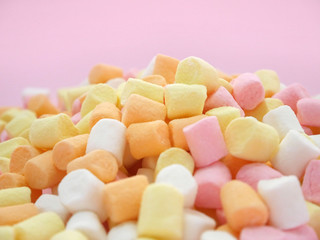 Pastel colored sweet marshmallow on pink background.