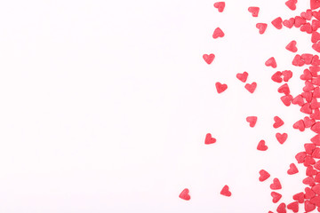 Pink heart shaped sprinkles on white background
