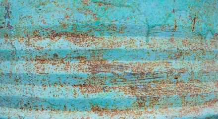 Cracked paint on rusty metal. Background texture cracked paint the color of sea foam and mint, visible rusty metal surface