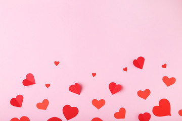 Red paper hearts on pink background