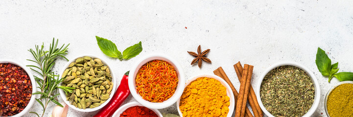 Spices and herbs on white stone table.