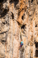 A girl climbs a rock.