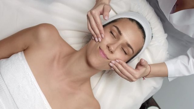 Top view of Cosmetology facial massage procedure young woman