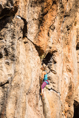 A girl climbs a rock.