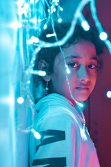 Fototapeta na wymiar little girl playing with garland fairy lights