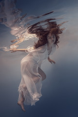 Portrait of a girl in a white dress under water