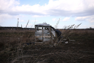 Fototapeta premium A wooden hut in the middle of a field collapses in windy weather.