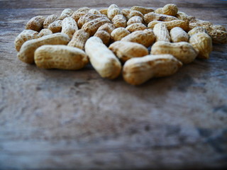 Fototapeta na wymiar peanuts in shell on wood background