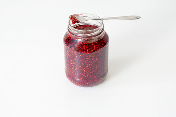 Glass jar with red jam on the table