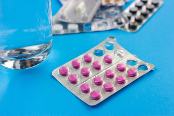 various packs of pills on a blue background.