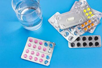 various packs of pills on a blue background.