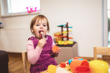 Cute child playing on table indoor, selective focus.