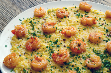 seafood risotto decorated with parmesan, parsley and pink pepper 