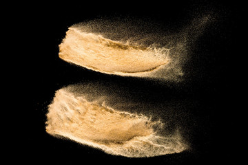 Dry river sand explosion isolated on black background. Abstract sand cloud.Brown colored sand splash against dark background.