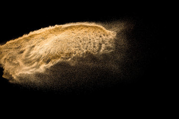 Dry river sand explosion isolated on black background. Abstract sand cloud.Brown colored sand...