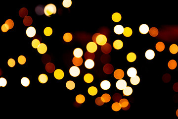 Holiday glowing gold backdrop. defocused and blurred many round yellow light on Christmas black background