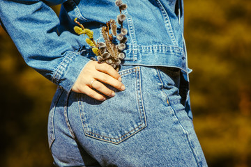woman ass in jeans blooming flowers in pocket