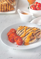 Grilled chicken breast with sauce and cherry tomatoes