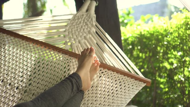 Feet resting in swing hammock summer nature relax