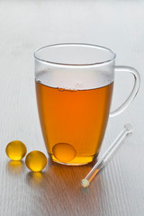 Glass of tea with yellow honey pearls