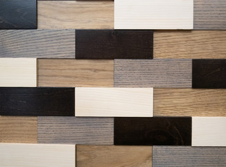 abstract geometric pattern wall made of wooden bricks in black, white, grey and brown colors