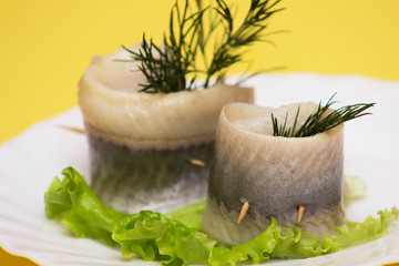 Marinated herring rollmops. yellow background. Free space for text