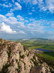 Fototapeta premium View of the Azriel Valley from the Mount of Exile in Nazareth. Sunny day, white clouds in the blue sky and green fields from the height of bird flight.