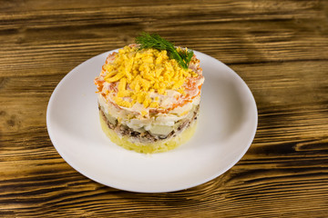 Traditional russian salad Mimosa on wooden table