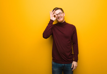 Young smart man confident doing ok gesture on eye