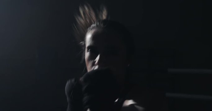 Female boxer fist close up - boxer strikes into the side of the camcorder. Spectator video boxing. The woman is striking the opponent