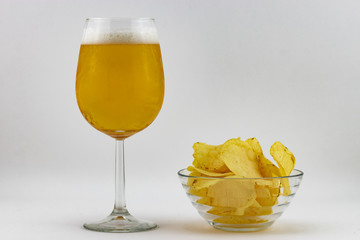 Birra fredda in bicchiere e patatine fritte