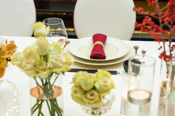 flowers and cutlery with glass around the plate decorated with a napkin when making a serving of the evening table