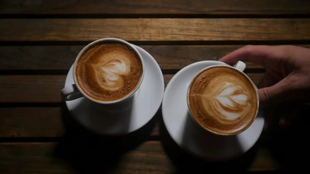 White cup of coffee over wooden background