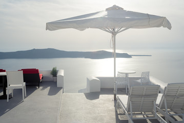 Sun umbrella, table and chairs against sea view