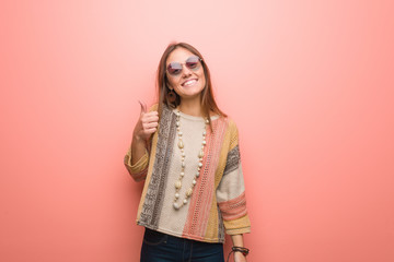 Young hippie woman on pink background smiling and raising thumb up