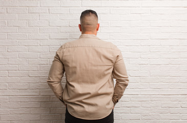 Obraz premium Young latin man from behind, looking back