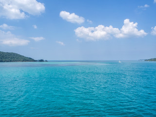 Fototapeta premium White yacht floating in the turquoise sea to the island with clouds. Koh Phangan. Thailand. 