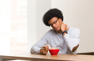 Fototapeta na wymiar Young black man having a breakfast suffering neck pain