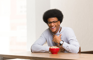 Fototapeta na wymiar Young black man having a breakfast laughing and having fun