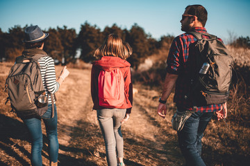 Rear view of family hiking on a dirty road