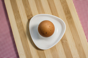brown farm egg on a pink background. Easter.
